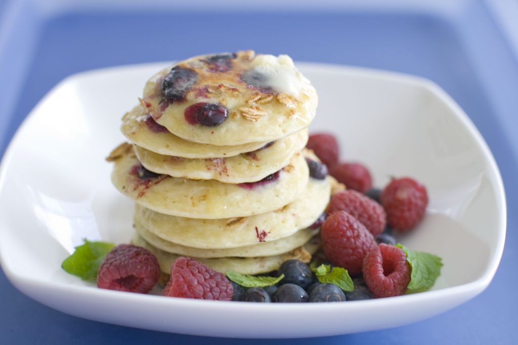 A plate of pancakes with blueberries