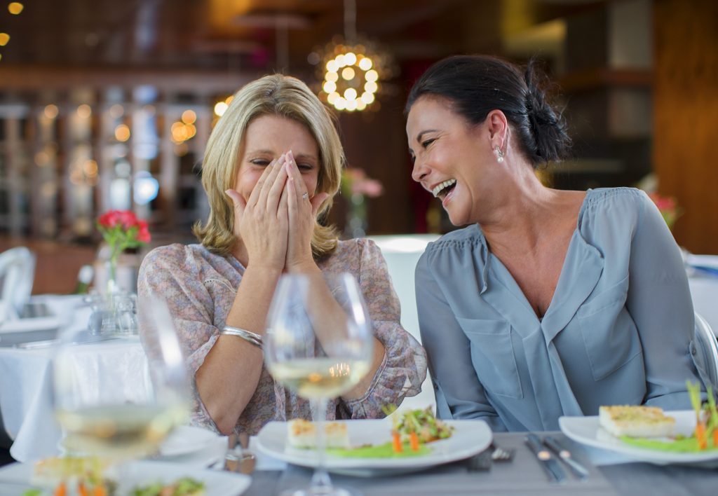 Two women laugh at restaurant