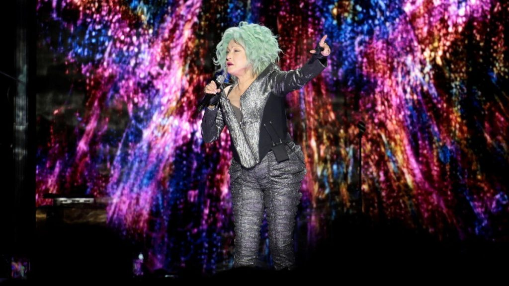Cheveux jaunes, justaucorps doré, foulard arc-en-ciel : Cyndi Lauper en fait voir de toutes les couleurs